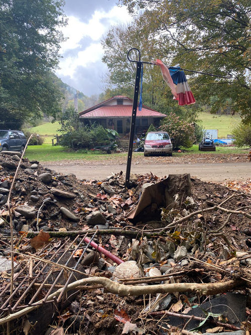 A pile of rubble and items like grates and garden hoses sit washed up from Hurricane Helene floodwaters in Roan Mountain.