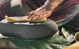 A woman on Fatu Hiva pounds the inner bark of a shrub to make tapa cloth, which local artists use as a canvas.