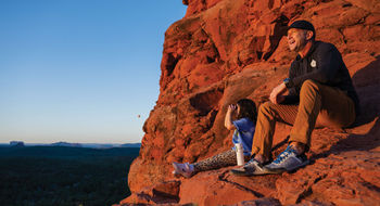 The author's daughter and Adventures by Disney guide Michael Hage contemplate the landscape on a sunrise hike in Sedona, Ariz.