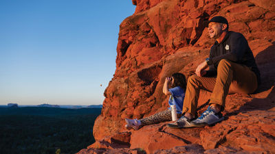 The author's daughter and Adventures by Disney guide Michael Hage contemplate the landscape on a sunrise hike in Sedona, Ariz.