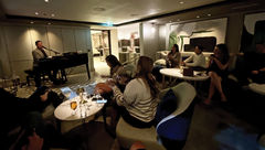 ASTA River Cruise Expo attendees on the Riverside Mozart sing in The Cove piano bar.