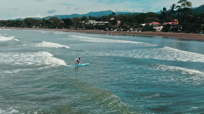 A Surf Synergy guest surfing in Jaco, Costa Rica.