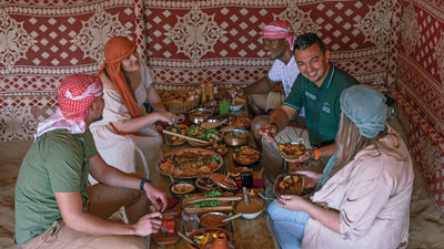 The four-course feast that is part of the Platinum Heritage safari experience is enjoyed in traditional Emirati fashion, at a stout and simple wooden table while sitting on a cushioned, backless chair.