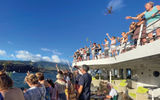 Passengers throw flowers in the water as they depart Ua Huka, the last island visited in the Marquesas.