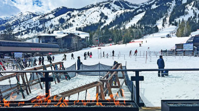 The patio at the Four Seasons Resort Jackson Hole's Handle Bar provides a front-row seat to the resort's base lifts and stunning mountains.