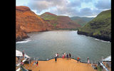 The ship moored horizontally across a canyon bay as the sun rose over Ua Huka.