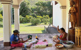 Two women outside a church on Ua Huka string leis.